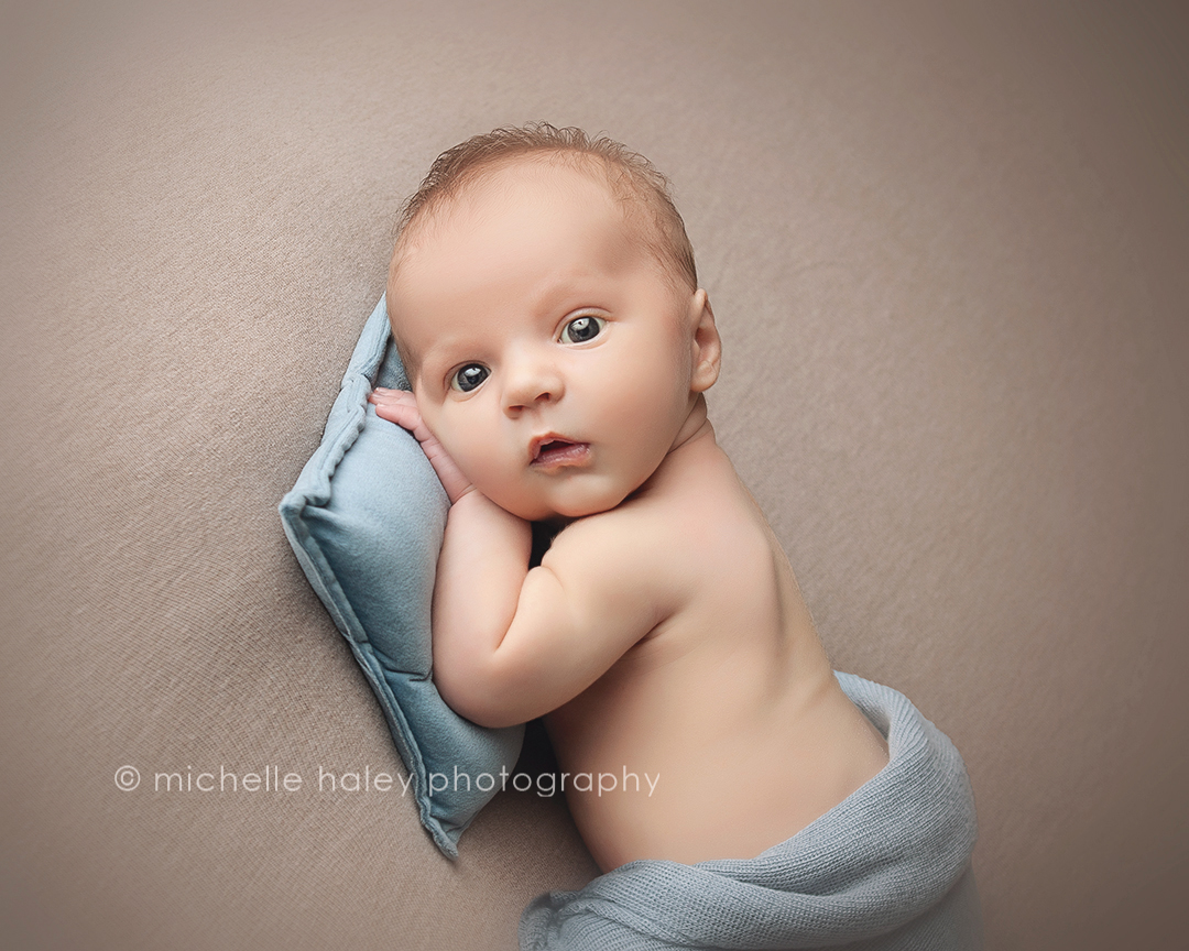Awake newborn baby photographed in blue wrap during Atlanta newborn photography session